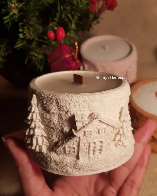 This is our Winter Lights Jar Candle, one of our absolute favorites. We designed this piece to feel like a cozy winter cabin, with intricate snowy details hand-carved into the Jesmonite jar. It’s filled with pure soy wax and a crackling wooden wick to bring warmth and peace to your space.