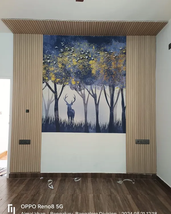 This accent wall is a great example of mixing materials. The serene forest and deer mural is flanked by light wood fluted panels, creating a modern yet natural focal point.