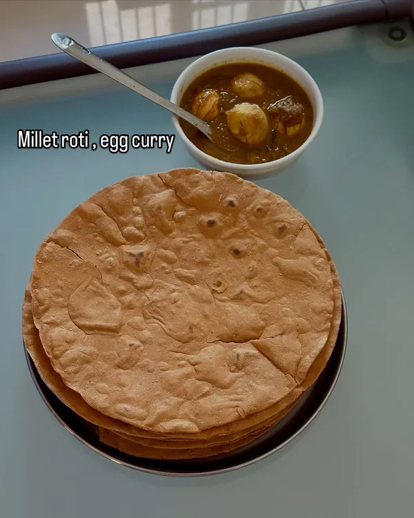 A simple and comforting meal of millet roti served with a flavorful egg curry.