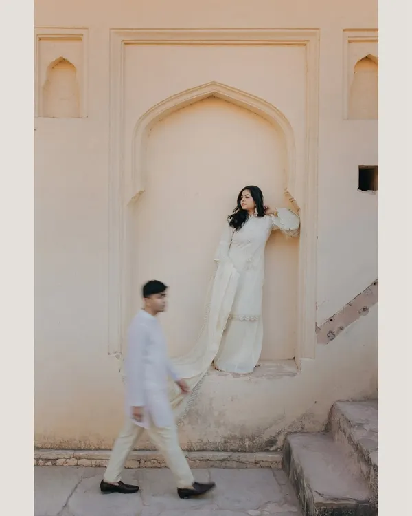 An artistic and unconventional pre-wedding shot of Vedika and Yuvraj in Jaipur. The motion blur of the groom walking past the bride creates a dynamic and intriguing narrative, showcasing our creative approach.