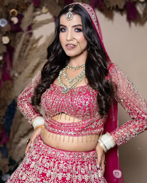 A vibrant pink lehenga paired with a dramatic smokey eye. This is a student's work from our portfolio day, showing their skill in creating bold, contemporary bridal looks.