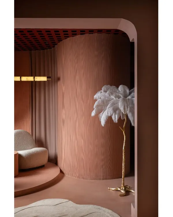 This detail shot from one of our award-winning projects shows our love for sculptural forms. The curved wall, finished in warm wood, creates a soft, enclosing feeling, complemented by an artistic floor lamp.