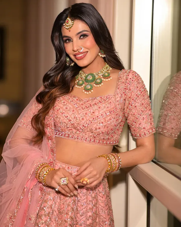 This is the look dreams are made of. I created this soft, rosy glow for a modern bride, focusing on radiant skin and gentle waves to complement her stunning pink lehenga and emerald jewelry.