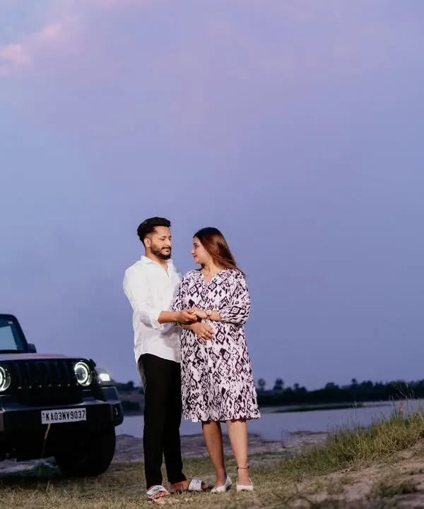 A couple shares an intimate moment at dusk next to their Mahindra Thar. The twilight sky adds a romantic and dramatic mood to this adventurous pre-wedding shot.