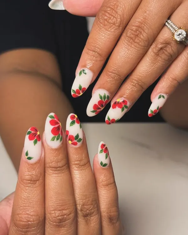 A beautiful and elegant set of almond extensions with a matte white base, covered in delicate, hand-painted red flowers.