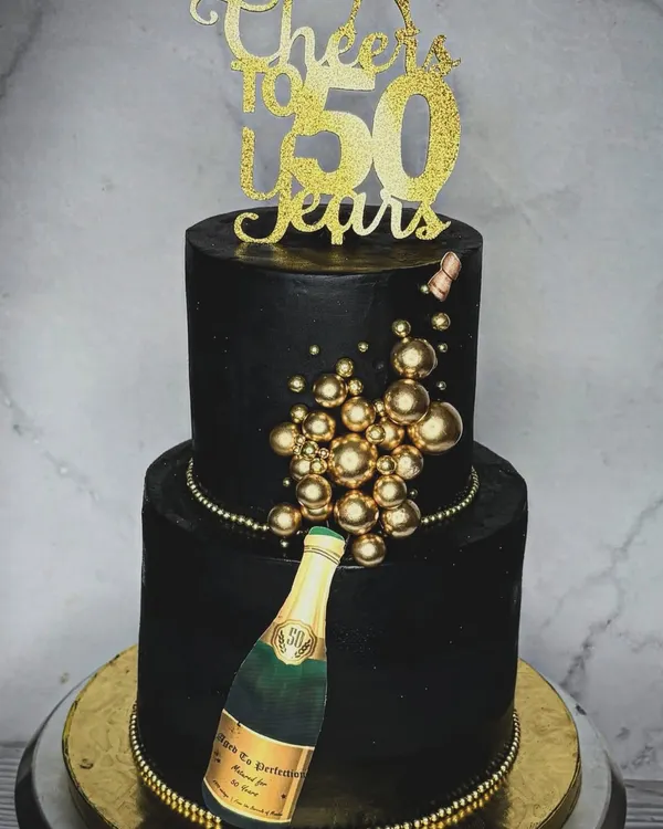 Turning half a century old is a big deal, and it calls for a showstopper cake. This two-tiered black and gold cake with a champagne bottle theme is the definition of a celebration centerpiece.