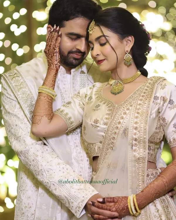 An intimate moment from a ring exchange ceremony. The groom's makeup is subtle, designed to even out his skin tone and keep him looking fresh for photos.