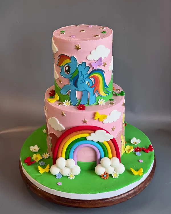 A full view of the dreamy 'My Little Pony' cake I made for Sara's 5th birthday. The two tiers provide a great canvas for telling a story with the colorful rainbow, fluffy clouds, and cute, handcrafted ponies.