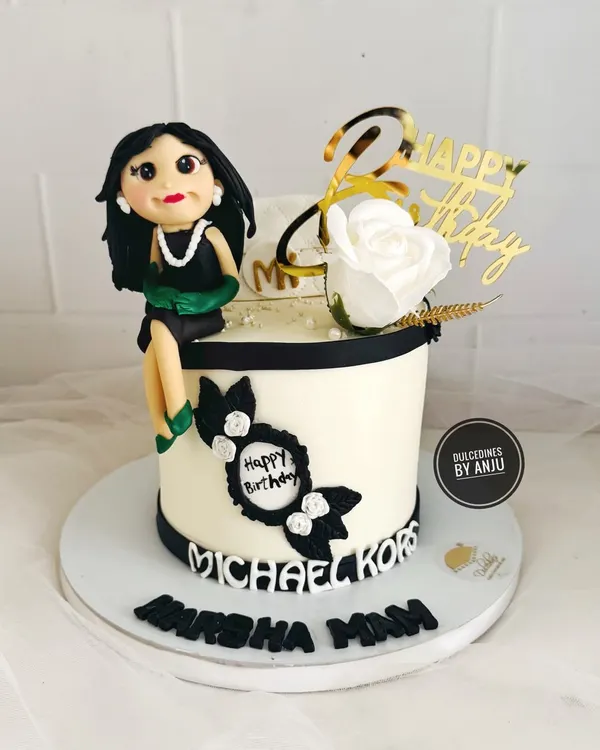 A chic and elegant cake for a fashion lover, featuring a handmade fondant figure, a Michael Kors logo, and classic black and white details.