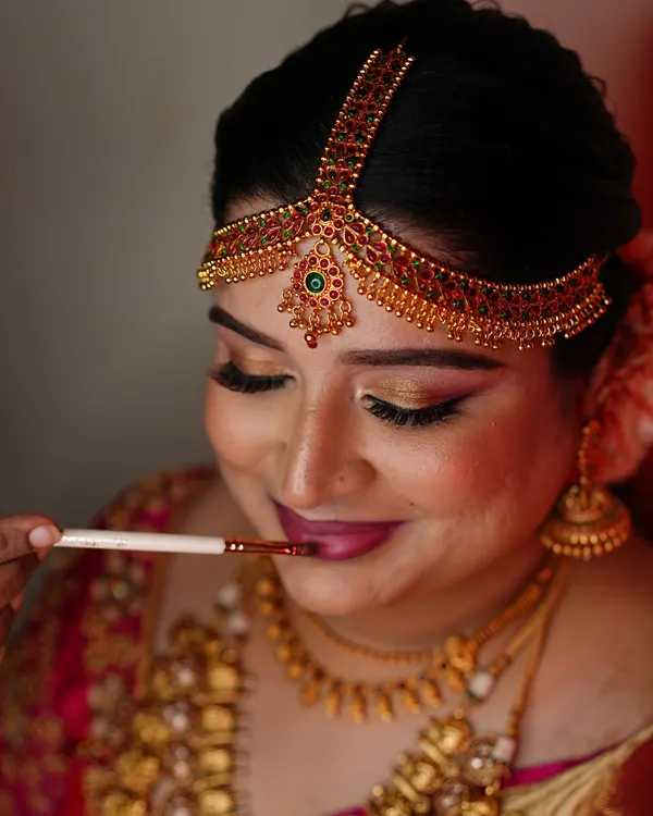 A close-up of the final touches. Applying lipstick is one of the last steps that brings the entire bridal look together. This is for Aishwarya's Brahmin wedding look.