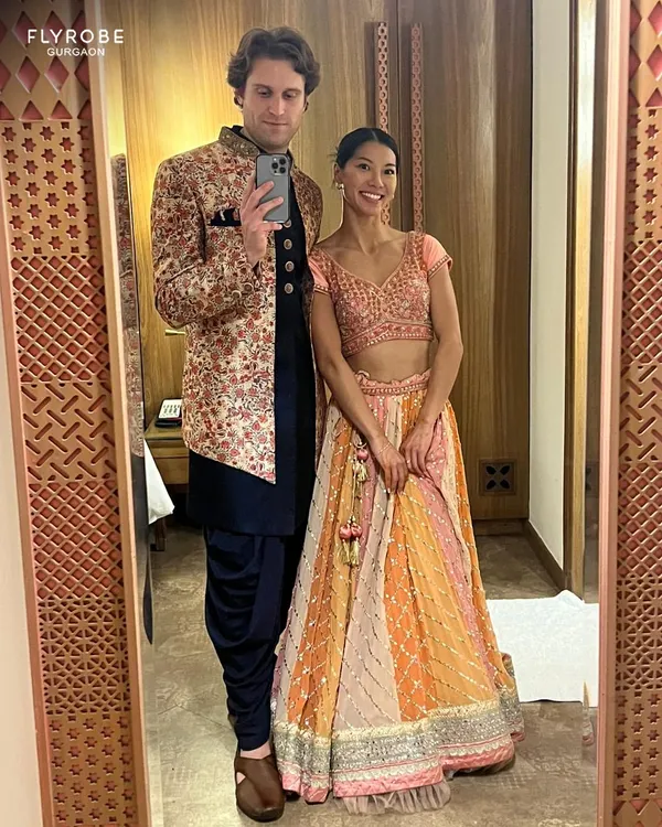 This mirror-selfie captures a great Indo-western look. The groom-to-be is wearing a floral embroidered bandhgala jacket over a dark kurta and dhoti pants, perfect for a vibrant Sangeet night.