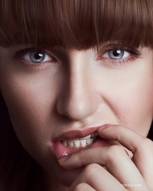 This is what I mean by real. A close-up beauty portrait where the lighting is everything. Notice the detail in the skin texture and the sharp catchlight in the eyes. This is the result of a commercial lighting setup that feels editorial, capturing an authentic and intense expression.