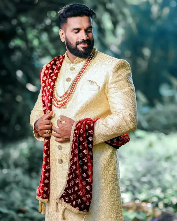 A groom's wedding day look is his ultimate statement. I crafted this custom cream sherwani with a contrasting velvet stole and dhoti pants to create a timeless and royal ensemble for his outdoor ceremony.