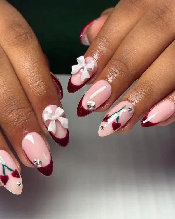 A super cute and trendy design featuring a deep red French tip, hand-painted cherries, and adorable 3D white bows.