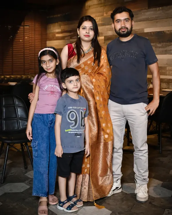 A classic portrait of a family of four. The parents stand with their two children, creating a timeless photo that is perfect for framing.