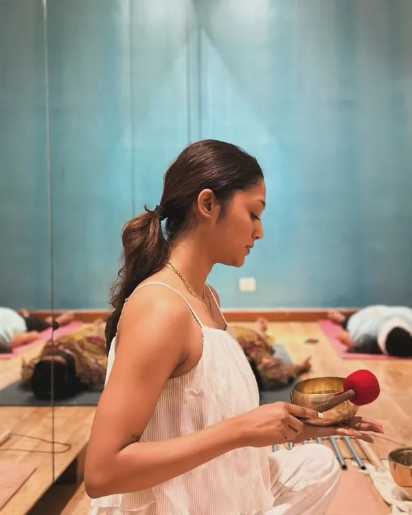 I hold a Tibetan singing bowl, preparing for a sound healing session. Each bowl has a unique frequency, and my focus is to create vibrations that help release tension and bring your body into a state of deep relaxation and harmony.