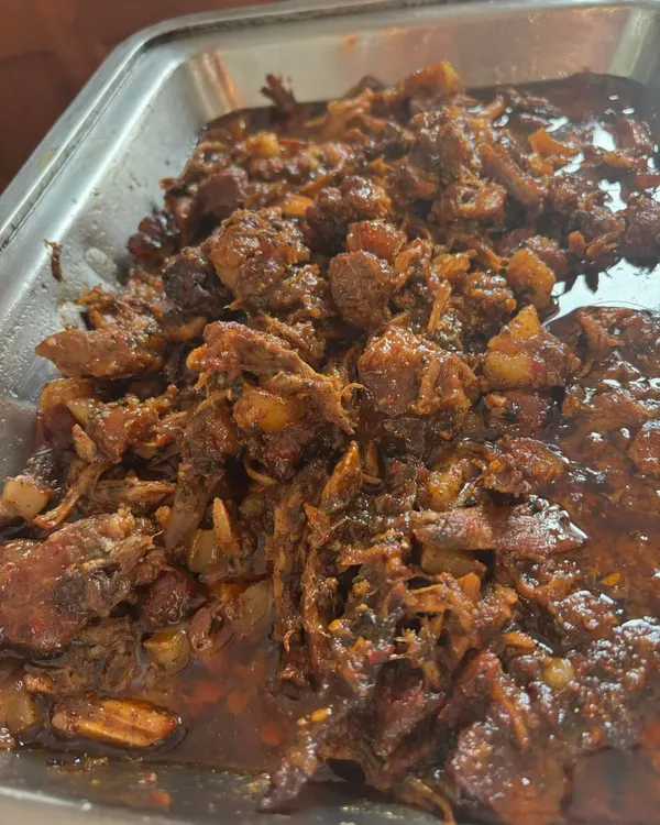 A tray of my rich, slow cooked pulled pork, ready to be served. It’s coated in its own flavourful tomato and BBQ reduction, perfect for filling burgers or baos.