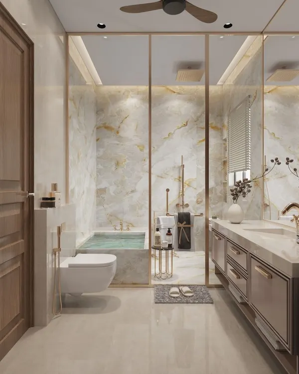This bathroom exudes a golden aesthetic, with warm-veined marble walls and brass fixtures creating a sense of classic luxury. The glass partition separates the wet and dry areas while maintaining an open, airy feel.