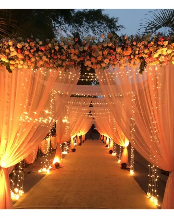 We believe the first impression is everything. This dreamy wedding entrance, with its warm fairy lights and flowing drapes, creates a magical pathway for you and your guests, setting the tone for a memorable celebration.