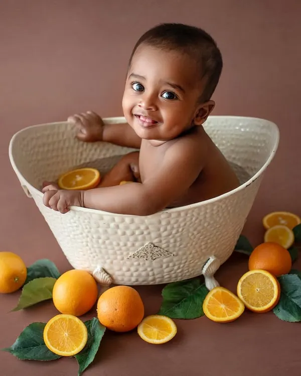 A happy little guy in his orange bath. The warm brown backdrop and bright oranges create such a beautiful, earthy color palette for this fun bath session.