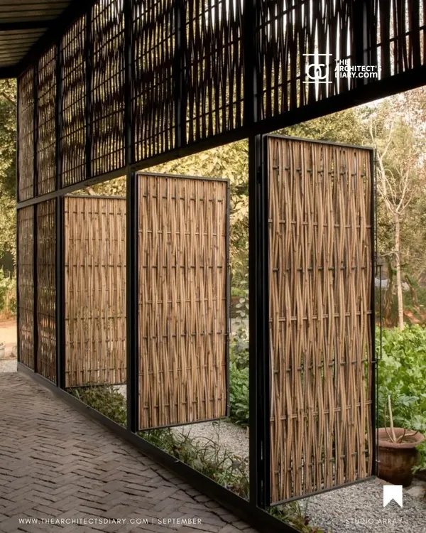 Weaving together steel and bamboo, these pivoting screens for an artist's residency in New Delhi create a porous boundary between the interior and the surrounding nature, filtering light and air.