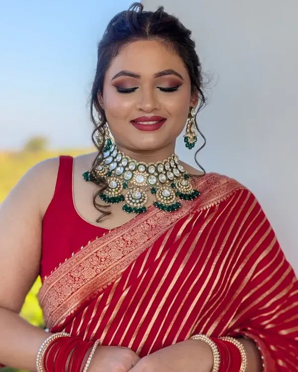 Understated glam for a special role. This soft glam look was created for a wedding guest, featuring a warm smokey eye and a classic red lip to complement her beautiful red saree.