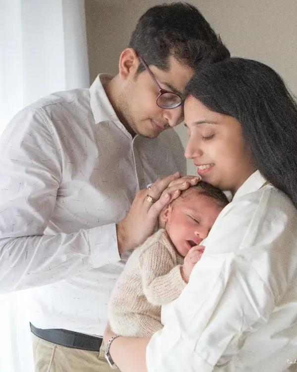 A beautiful, light-filled portrait of new parents adoring their sleeping baby. These are the quiet, intimate moments that truly define the newborn experience. I aim to capture the overwhelming love and wonder of this special time.
