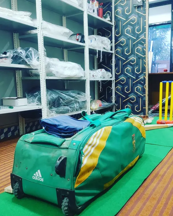 Our store stocks a variety of gear, including this Adidas wheelie kit bag. You can also see our wickets and other equipment ready for players.