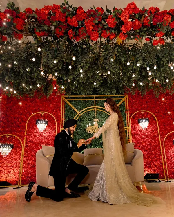 The moment it becomes official. I love capturing the proposal during a ring ceremony, set against a stunning backdrop of red roses and elegant decor.