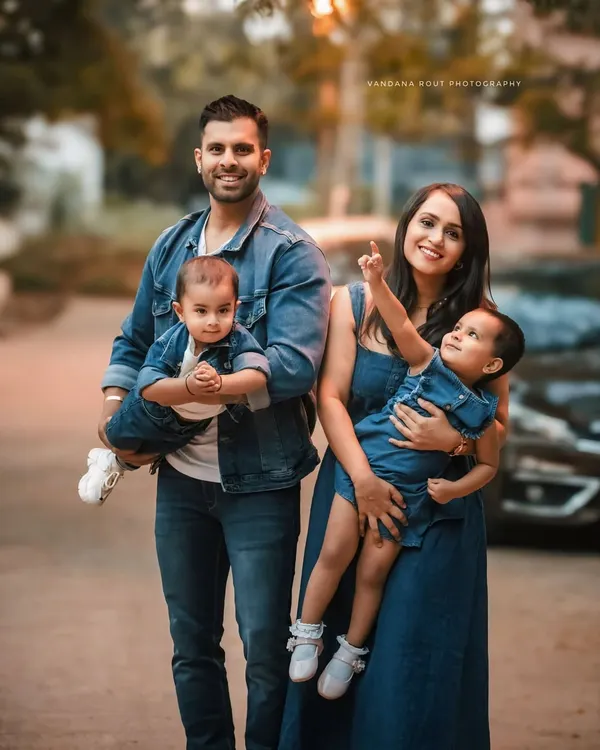 A perfect family portrait, with everyone dressed in matching denim. This outdoor shot captures a candid moment of joy and togetherness, showing the fun and love this family shares.