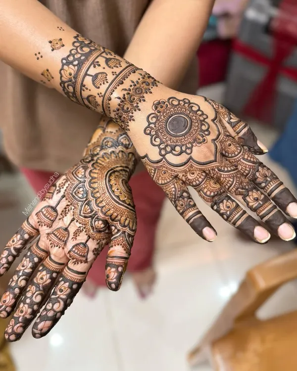 A gorgeous engagement mehendi for a dear friend. This design features a prominent mandala on the back of the hand, with delicate patterns extending up the arm, leaving some skin showing for a balanced look.