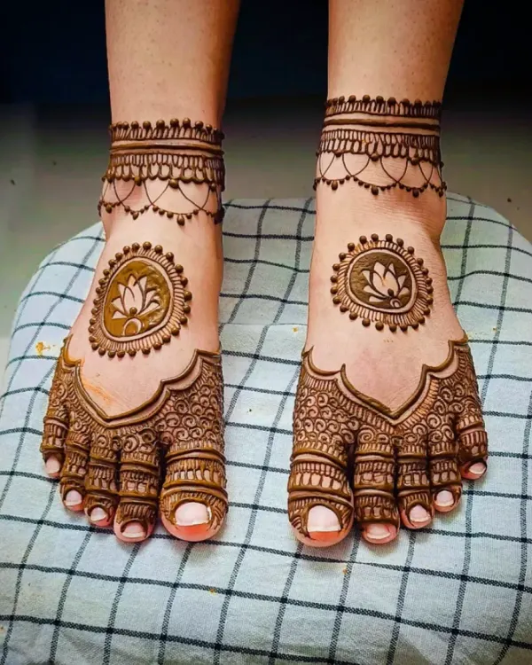A simple yet elegant feet design featuring a lotus mandala in the center, with a delicate chain-like pattern around the ankles.