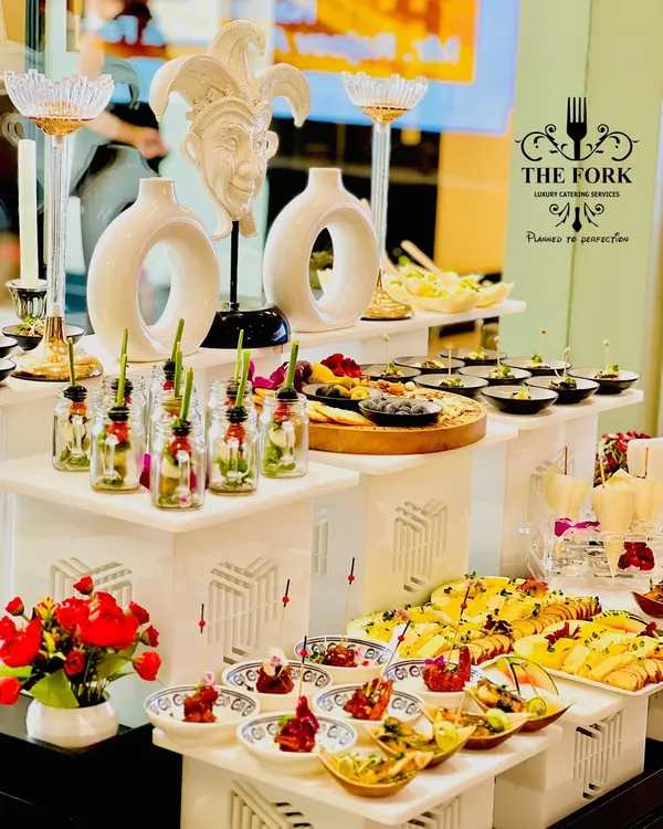 A multi-tiered appetizer station showcasing a variety of canapés and small bites. The artistic decor elements and thoughtful arrangement highlight our philosophy of treating food presentation as an art form.