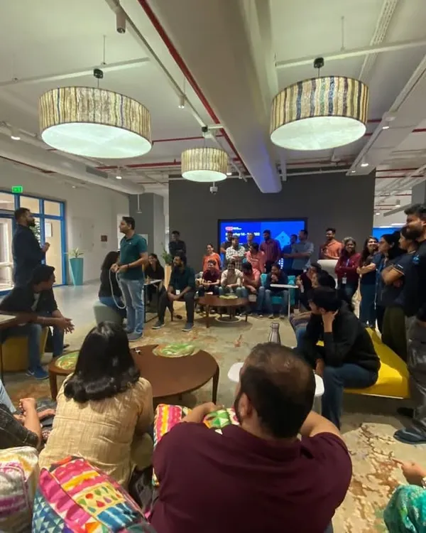 Leading an informal team-building session in a relaxed office lounge area. These workshops are designed to be casual and interactive, encouraging open participation and connection among colleagues.