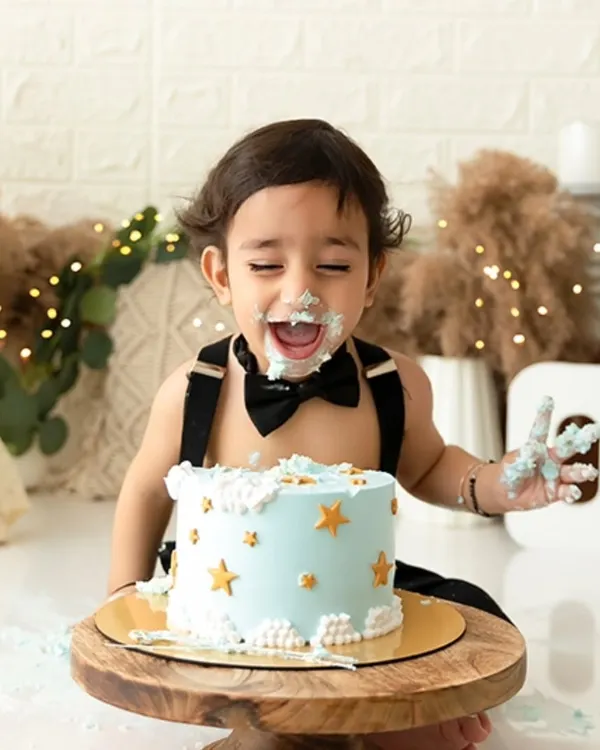 A candid shot from a boho-themed cake smash, capturing the pure joy and laughter as this little one enjoys his first birthday cake.