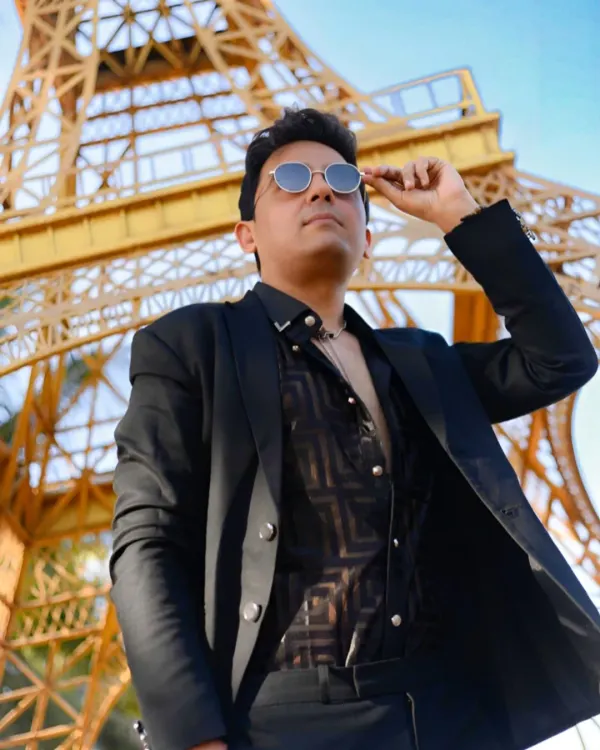 A stylish solo portrait with a low-angle shot against a replica of the Eiffel Tower. This kind of creative angle can make a portrait stand out.