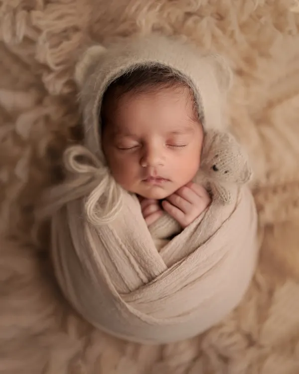 There's nothing sweeter than a baby in a bear bonnet. This cozy, neutral setup with a tiny teddy bear friend is a classic for a reason. It's all about capturing that innocent, sleepy perfection.