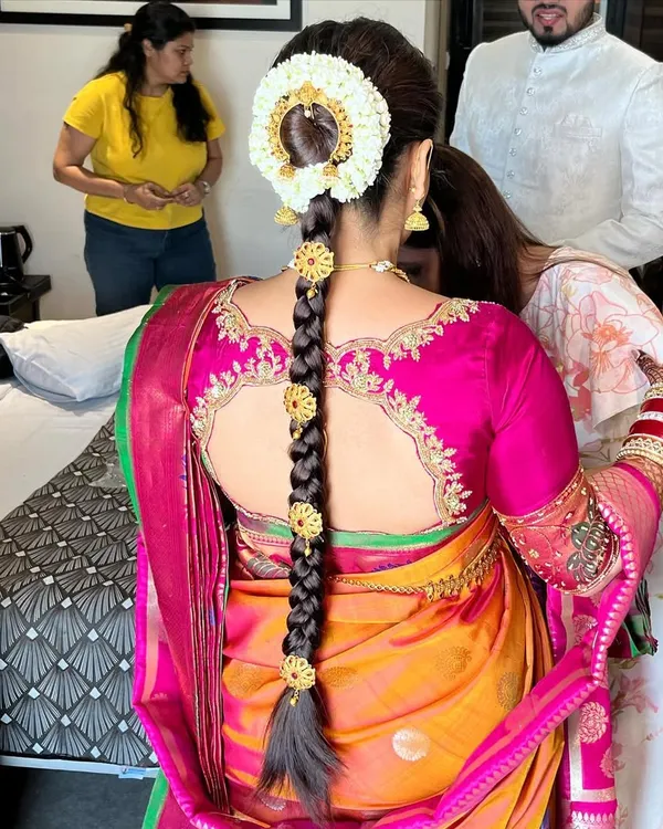 A stunning South Indian bridal braid, intricately woven and decorated with traditional gold ornaments and a fresh jasmine gajra. This hairstyle is the epitome of South Indian bridal beauty.