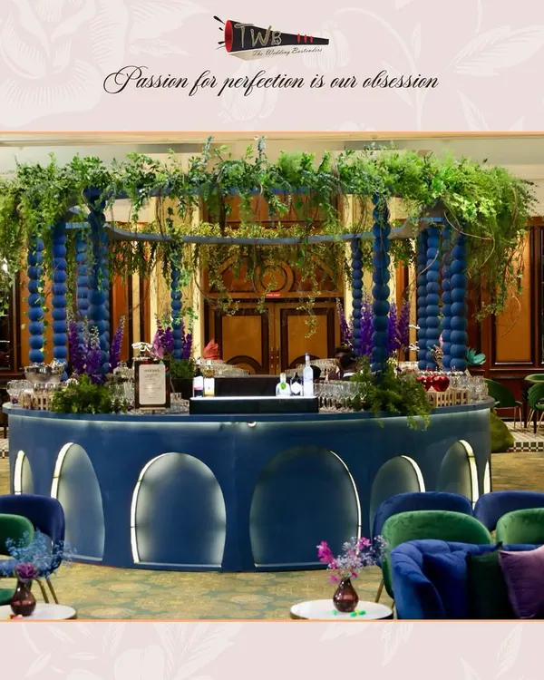 A breathtaking circular bar setup, adorned with lush greenery and florals, creating an immersive and luxurious atmosphere for a sangeet night at Taj Lands End.