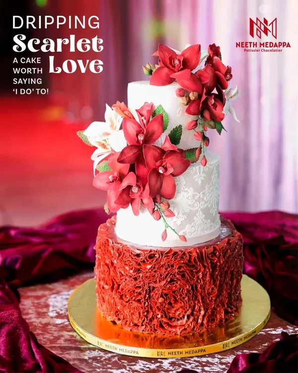 This is what I call edible drama. A three-tiered wedding cake in scarlet and ivory, featuring a cascade of handcrafted scarlet sugar flowers and delicate lace stenciling. It's a bold statement piece for a love story that deserves to be celebrated in style.