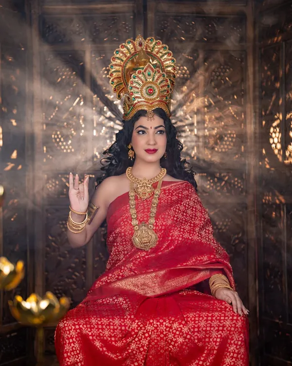 A powerful and divine look created for a Varamahalakshmi festival shoot. The makeup is regal, with bold red lips and defined eyes, complemented by a traditional crown and heavy gold jewellery to embody the goddess.