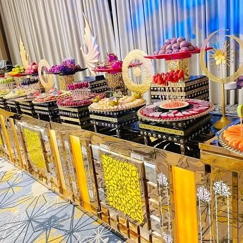 A glimpse of our artistic fruit and dessert arrangements. We believe a feast should be as beautiful as it is delicious, and this vibrant display with fresh fruits, Indian sweets, and pastries is designed to be the stunning centerpiece of your celebration.