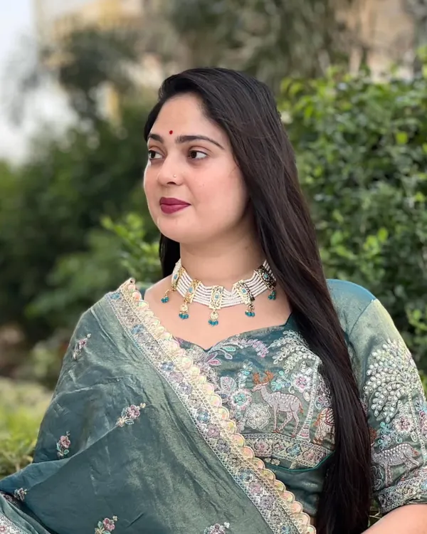 A client looking absolutely radiant in our Apsara necklace set. The white and turquoise combination stands out beautifully against her emerald green outfit, showing how the right jewellery can complete a look.