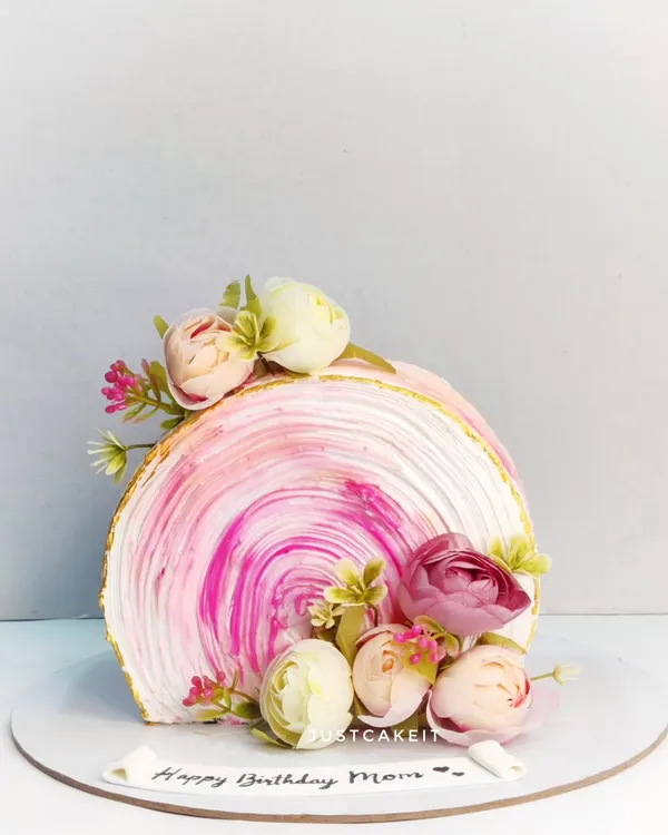 An elegant top-forward cake with a beautiful pink swirl texture. This modern design was for a mom's birthday and featured a new Rose Litchi flavor.