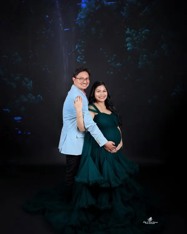 A couple's portrait showcasing our elegant dark green ruffled gown. The deep color provides a rich, luxurious feel, perfect for a dramatic and timeless look.