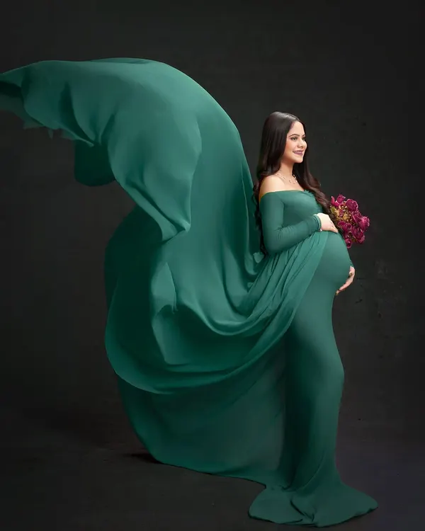 A statement piece from our studio collection, this portrait uses a flowing emerald gown and dramatic lighting to create a powerful and elegant image. We focus on creating motion and grace to highlight the beauty of pregnancy.