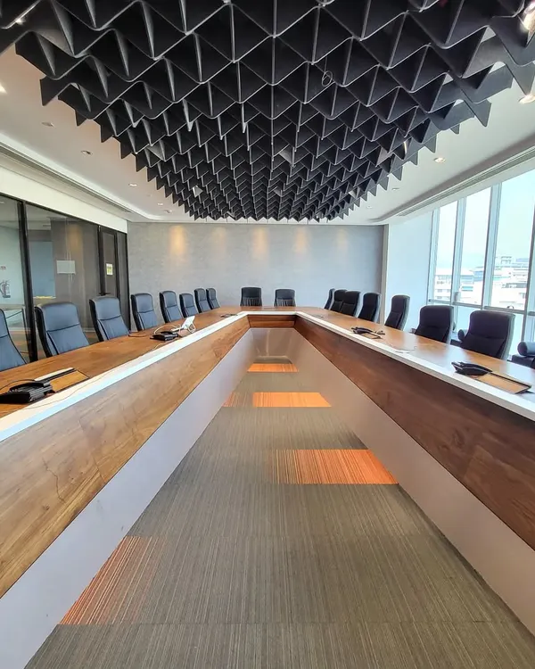 This conference room was designed for serious business. The custom U-shaped table encourages discussion, while the geometric acoustic ceiling is not just a design feature; it's crucial for sound management during important calls and meetings.