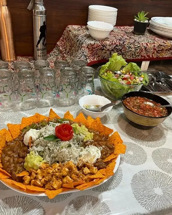 A full view of a healthy meal spread I prepared. The centerpiece is a loaded nacho platter, surrounded by fresh salad and salsa, showing how you can enjoy a feast that is both satisfying and nutritious.