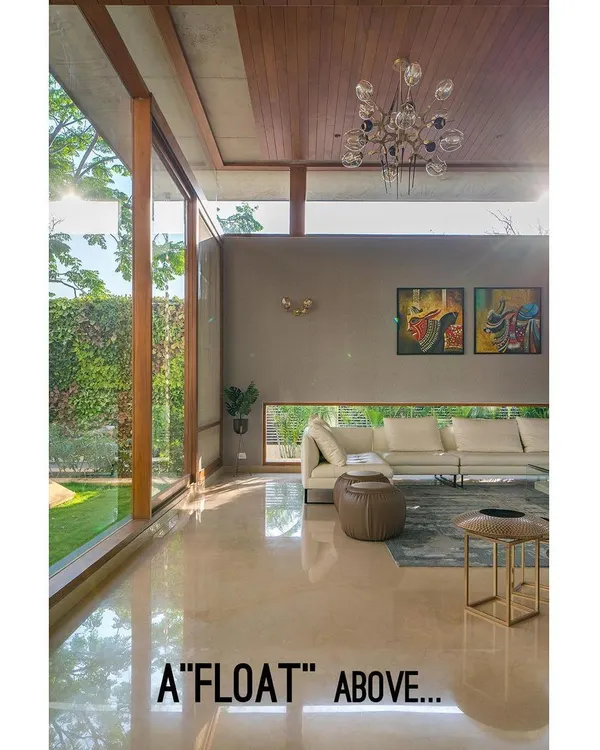 The living room ceiling appears to float above the walls, an architectural choice that enhances the feeling of height and openness in this Bengaluru home.