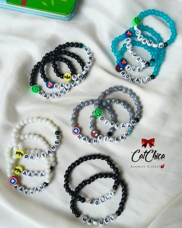Our custom name bracelets for boys are always a hit! We use a variety of bead colors and fun charms like superheroes to match their style.